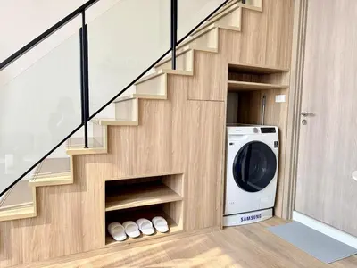 a laundry room with a washer and dryer under the stairs at 5 Min walk to BTS Onnut Duplex Loft At Sukhumvit in Amphoe Phra Khanong