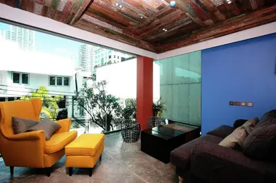 a living room with a couch and chairs and a large window at Aspira D'Andora Sukhumvit 16 - Asoke in Bangkok
