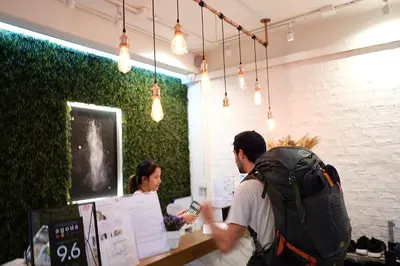 a man with a backpack standing at a counter with a woman at Lamurr Sukhumvit 41 in Bangkok