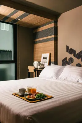 a tray of food sitting on top of a bed at NAP Hotel Bangkok in Bangkok