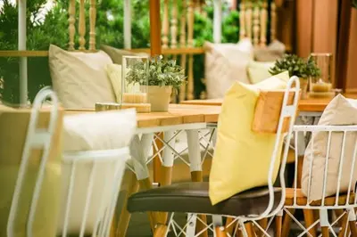 a dining room table with chairs and a yellow pillow at NAP Hotel Bangkok in Bangkok