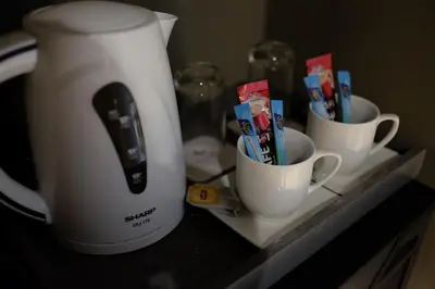 two cups with toothbrushes in them on a shelf at NAP Hotel Bangkok in Bangkok