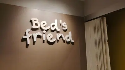 a sign on a wall that reads beds friend at Bed's Friend in Bangkok
