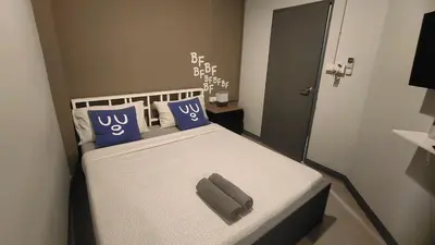 a bedroom with a bed with blue pillows and a mirror at Bed's Friend in Bangkok