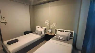 two beds in a small room with blue curtains at Bed's Friend in Bangkok