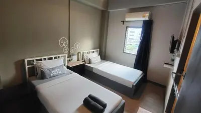 a small room with two beds and a window at Bed's Friend in Bangkok