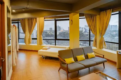 a living room with a couch and large windows at Metro Pratunam Boutique Hotel in Pratunam