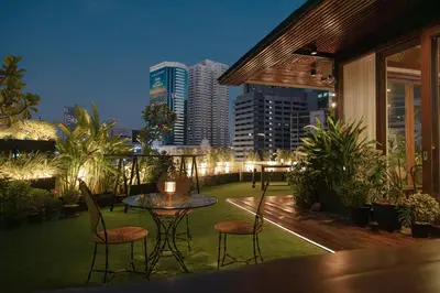 a balcony with a table and chairs and a city skyline at Metro Pratunam Boutique Hotel in Pratunam