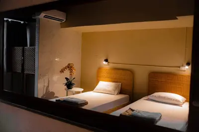 a mirror reflection of a bedroom with two beds at Metro Pratunam Boutique Hotel in Pratunam