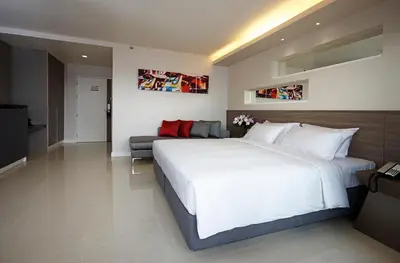 a bedroom with a large white bed and a couch at Praso@Ratchada12 in Bangkok