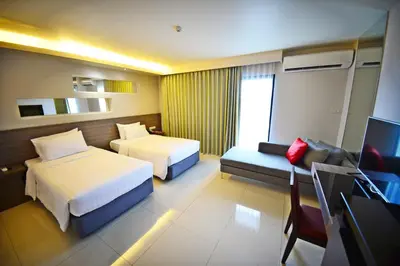 a hotel room with two beds and a television at Praso@Ratchada12 in Bangkok