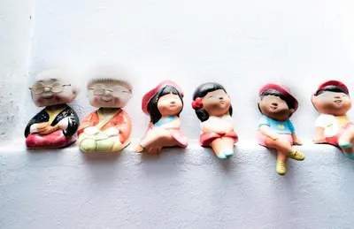 a group of dolls sitting on a wall at Check-in My Hostel in Bangkok