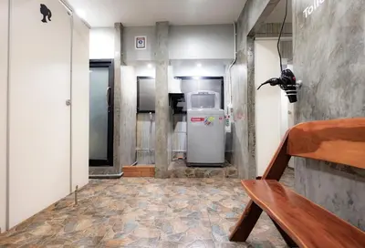 a hallway with a refrigerator and a wooden bench at Check-in My Hostel in Bangkok
