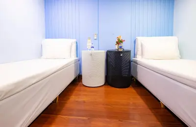 two beds in a room with white beds at Check-in My Hostel in Bangkok