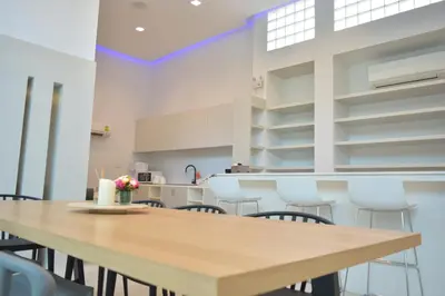 a kitchen with a wooden table and chairs at Rezt Bangkok in Bangkok