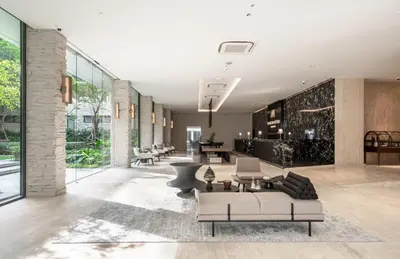 a lobby with couches and chairs in a building at Maison Hotel Bangkok in Bangkok