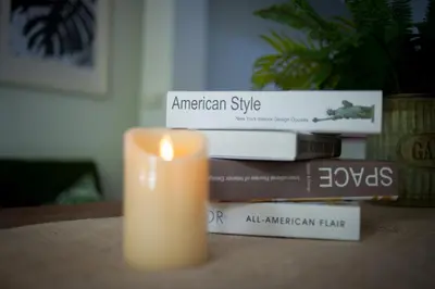 a candle sitting next to a stack of books at Victory Park Hostel in Bangkok