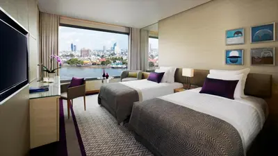 a hotel room with two beds and a large window at Avani Plus Riverside Bangkok Hotel in Bangkok