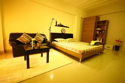 a bedroom with a bed and a couch and a table at At Home Phetkasem in Bangkok