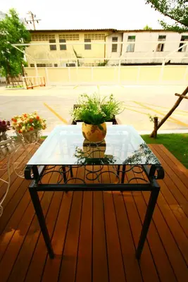 a glass table on a deck with a plant on it at At Home Phetkasem in Bangkok