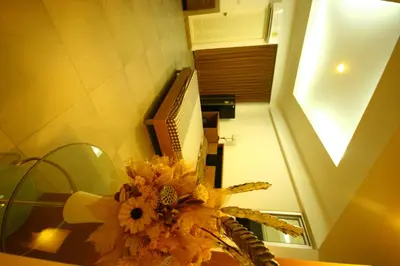 a room with a table with flowers and a box at At Home Phetkasem in Bangkok