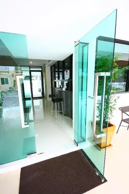 a glass house with a living room and a dining room at At Home Phetkasem in Bangkok