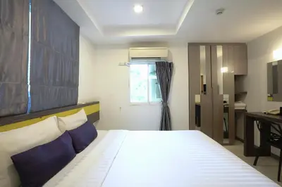 a bedroom with a large bed and a window at Cubic Pratunam in Bangkok