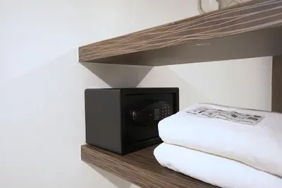 a microwave sitting on a shelf next to some towels at Cubic Pratunam in Bangkok