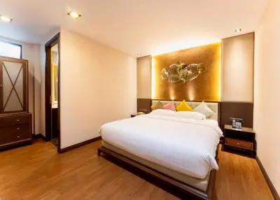 a bedroom with a large white bed in a room at Chiva Bangkok Hotel in Bangkok