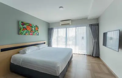 a bedroom with a bed and a large window at Chiva Bangkok Hotel in Bangkok