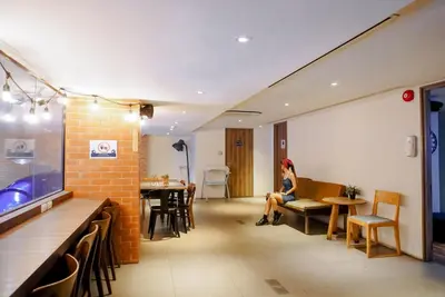 a woman sitting on a bench in a room at Kokotel Bangkok Surawong in Bangkok