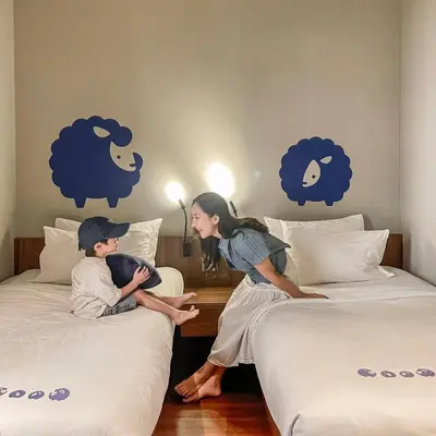 a man and a woman sitting on two beds at Kokotel Bangkok Surawong in Bangkok