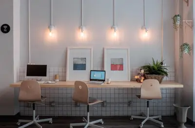 an office with a desk with a laptop and two chairs at Movylodge in Bangkok