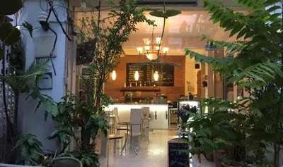 a kitchen with a table and chairs and plants at Oriental Smile Hotel in Bangkok