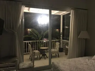 a bedroom with a bed and a balcony with a table and chairs at Oriental Smile Hotel in Bangkok