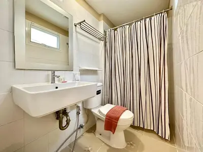 a bathroom with a sink and a toilet and a mirror at Dinsomon Hotel in Bangkok