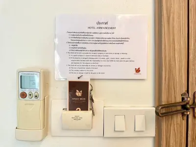 a certificate and a box with a cell phone at Dinsomon Hotel in Bangkok