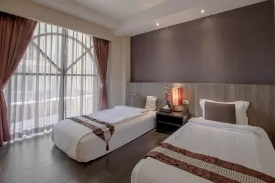 a hotel room with two beds and a window at The Star of Sathorn in Bangkok