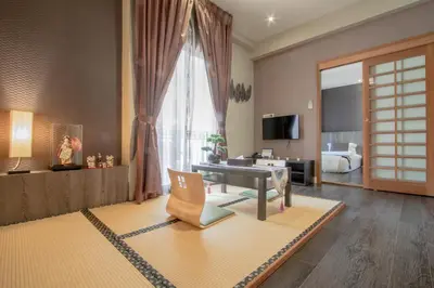 a living room with a couch and a room with a bed at The Star of Sathorn in Bangkok