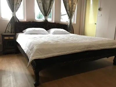 a bedroom with a large bed with white sheets and pillows at The Grand Palace Hotel in Bangkok