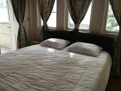 a bedroom with a bed with two pillows on it at The Grand Palace Hotel in Bangkok