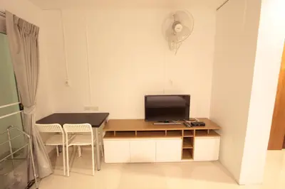 a room with a desk with a tv and a table and chairs at Napaville Huai Khwang in Bangkok