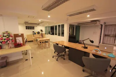 an office with a desk with a laptop and chairs at Napaville Huai Khwang in Bangkok