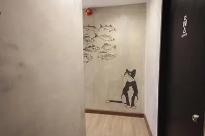a painting of a cat on a wall with fish at Cazz Hostel in Bangkok