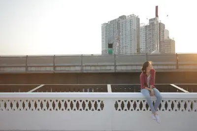 a girl sitting on the ledge of a bridge at Cazz Hostel in Bangkok