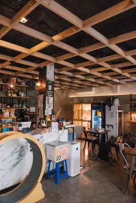a large room with tables and chairs in a room at Cazz Hostel in Bangkok