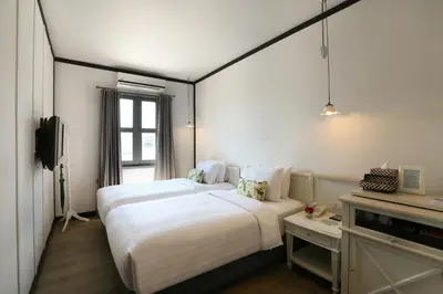 a hotel room with two beds and a television at The Raweekanlaya Bangkok Wellness Cuisine Resort in Bangkok