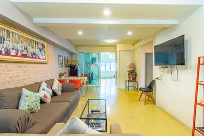 a living room with a couch and a tv at Sleep Dee Hostel in Bangkok