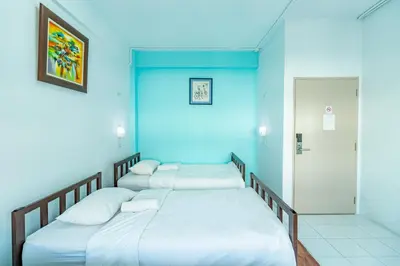 two beds in a room with a blue wall at Sleep Dee Hostel in Bangkok
