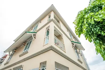 a tall white building with windows at The Orchid House 153 in Bangkok